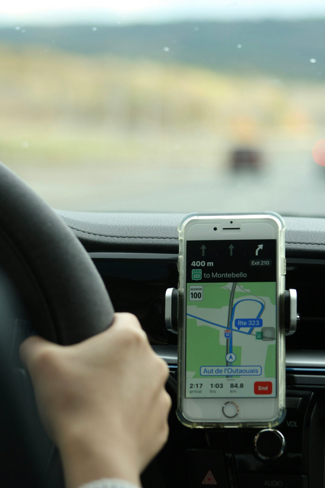 a person holding a cell phone while driving a car