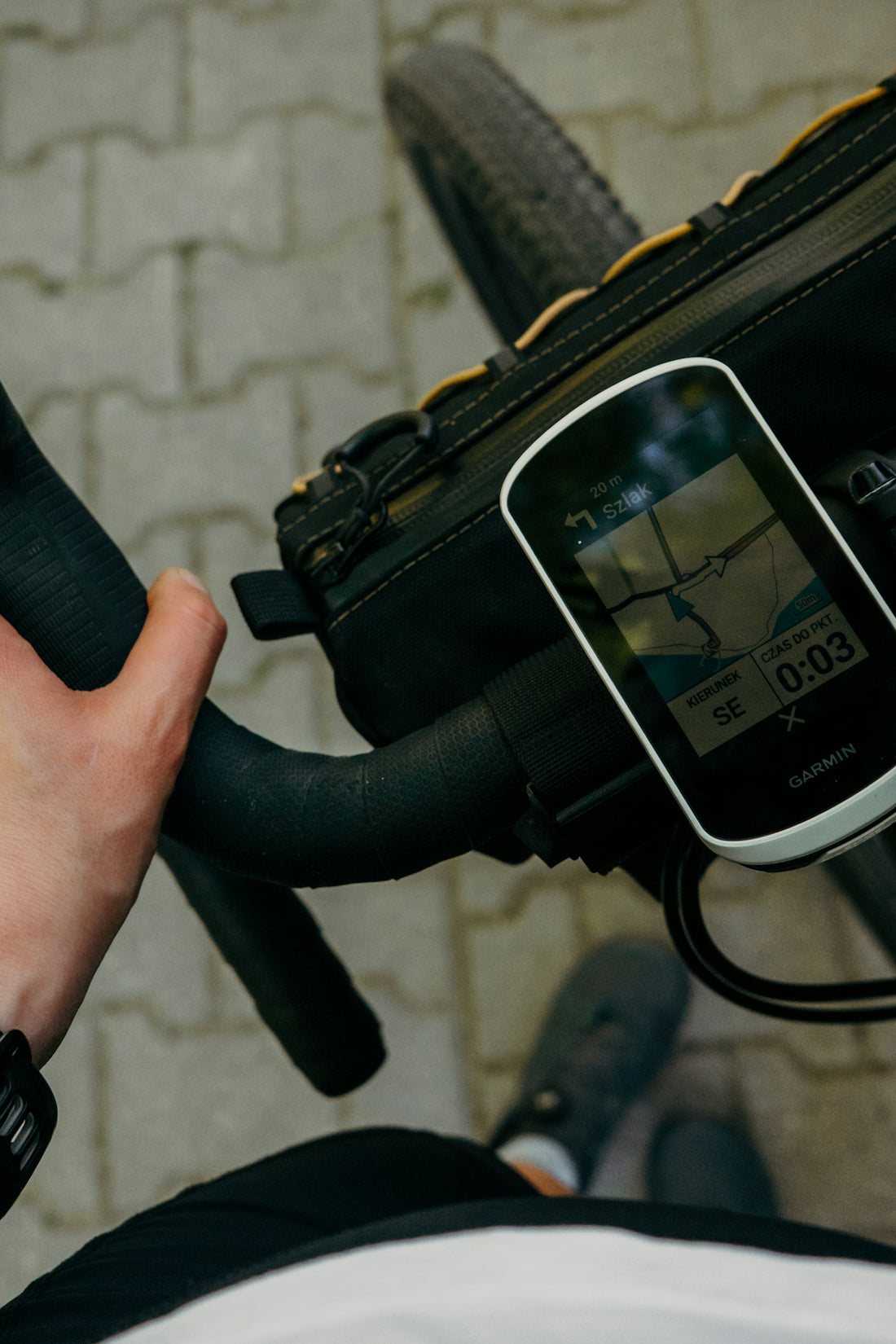 Cyclist's hand on handlebars with gps showing a map.